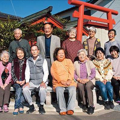 畑ヶ中自治会館に集う地域のみなさんと麻溝地区社協会長の境さん（福祉タイムズ2023年12月号）